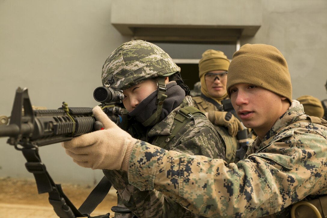 U.S. Marine Lance Cpl. Kyle Pantoja teaches Republic of Korea Marine Sergeant Lee Sang Ok how to properly shoulder a M16A4 service rifle at Gimpo Training Area, Republic of Korea, Feb. 27, 2016. Marines from both forces practiced urban and detention operations throughout the day. The training took place as part of Korean Marine Exchange Program 16-6, a regularly scheduled training event between the ROK and U.S. Marine Corps. This iteration of KMEP focuses on specialized training between military policemen with 3rd Law Enforcement Battalion, III Marine Expeditionary Force Headquarters Group, III MEF, and Military Police Company, 2nd ROK Marine Corps Division. Pantoja, from Trenton, New Jersey, is a military policeman with Company A, 3rd LE Bn. Lee, from Pohang, Republic of Korea, is a military policeman with MP Company, 2nd ROKMC Div. (U.S. Marine Corps Photo by Cpl. Steven Tran/Released)