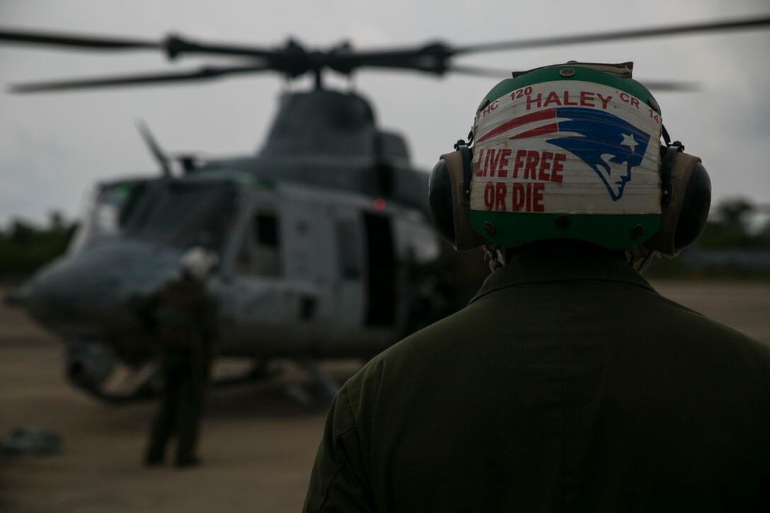 Sgt. Andrew A. Haley observes a UH-1Y Huey as it prepares to take off for a flight mission during exercise Cobra Gold 16 in Utapao, Thailand, February 16, 2016. Haley, an avid New England Patriots fan, is one of many maintainers who help prepare aircraft before and after takeoff. Cobra Gold is a multi-national exercise designed to advance regional security and ensure effective responses to regional crises by bringing together a robust combined task force from partner nations sharing common goals. Haley, from Conway, New Hampshire, is an airframe mechanic with Marine Light Attack Helicopter Squadron 167, currently supporting Marine Aircraft Group 36, 1st Marine Aircraft Wing, III Marine Expeditionary Force as part of the unit deployment program. (U.S. Marine Corps photo by Cpl. William Hester/ Released)