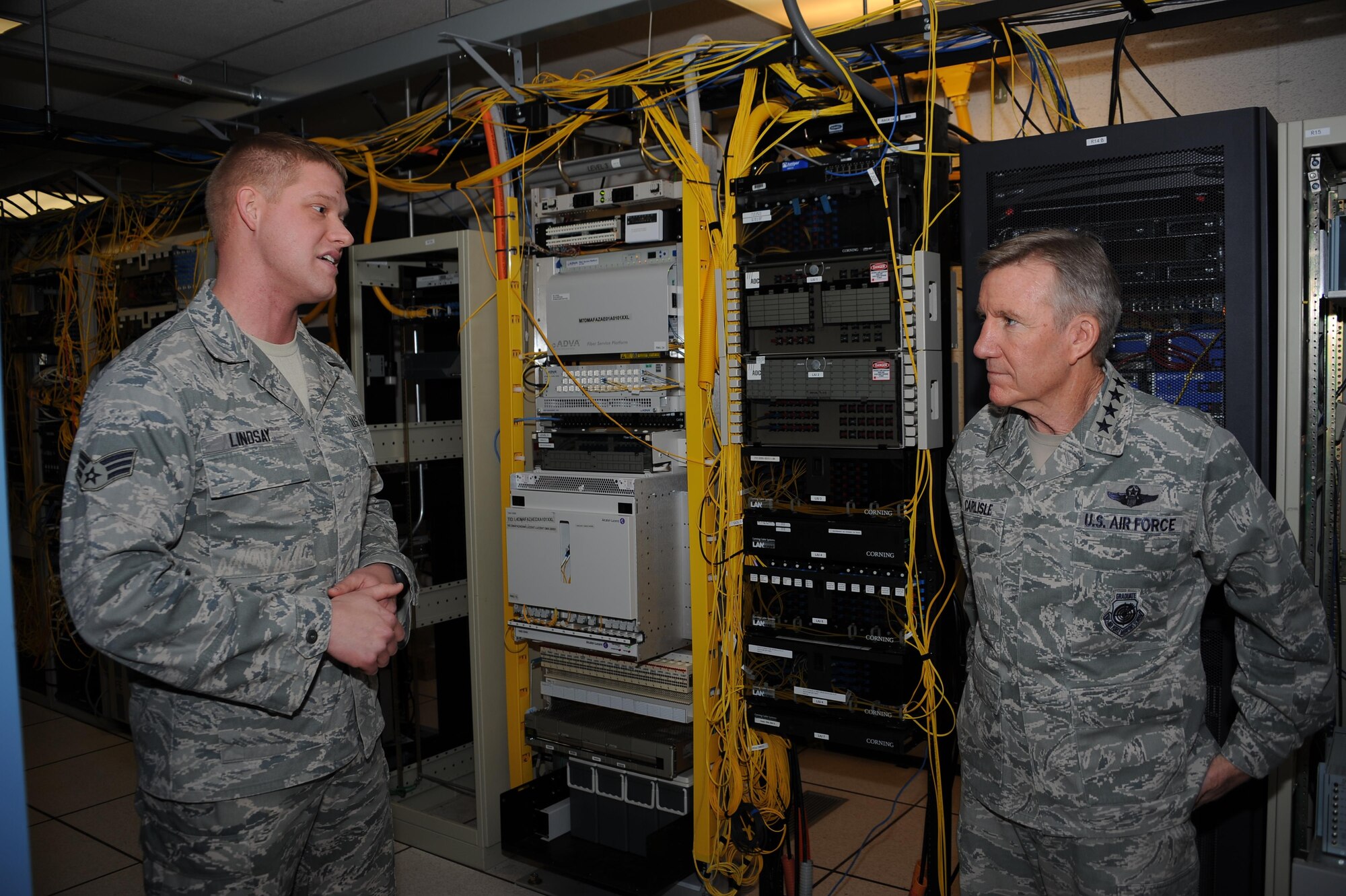 U.S. Air Force Senior Airman Mark Lindsay, 355th Communications Squadron network technician, speaks with U.S. Air Force Gen. Hawk Carlisle, commander of Air Combat Command, during a base tour at Davis-Monthan Air Force Base, Ariz., March 3, 2016. Carlisle visited various units during his tour, where Airmen briefed him about their part in completing the mission. Carlisle is responsible for organizing, training, equipping and maintaining combat-ready forces for rapid deployment and employment while ensuring strategic air defense forces are ready to meet the challenges of peacetime air sovereignty and wartime defense. (U.S. Air Force photo by Airman 1st Class Ashley Steffen/ Released) 