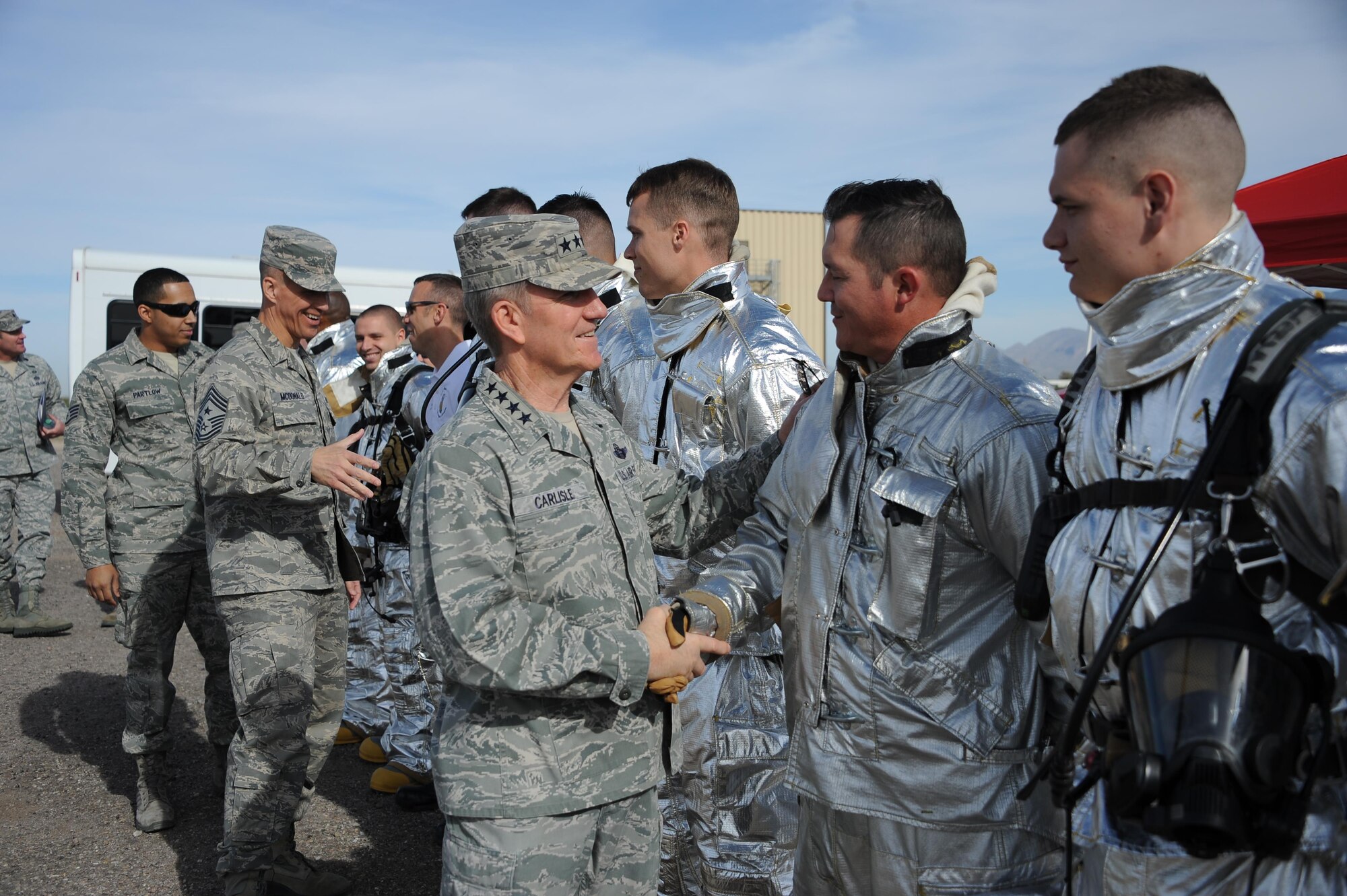 U.S. Air Force Gen. Hawk Carlisle, commander of Air Combat Command, and Chief Master Sgt. Steve McDonald, ACC command chief, meet 355th Civil Engineering Squadron fire emergency services flight Airmen during a base tour at Davis-Monthan Air Force Base, Ariz., March 3, 2016. The 355th CES Airmen had just conducted a live fire demonstration that Carlise and McDonald observed. ACC operates more than 1,300 aircraft, 34 wings, 19 bases, and more than 70 operating locations worldwide with 94,000 active-duty and civilian personnel. (U.S. Air Force photo by Airman 1st Class Ashley Steffen/Released)