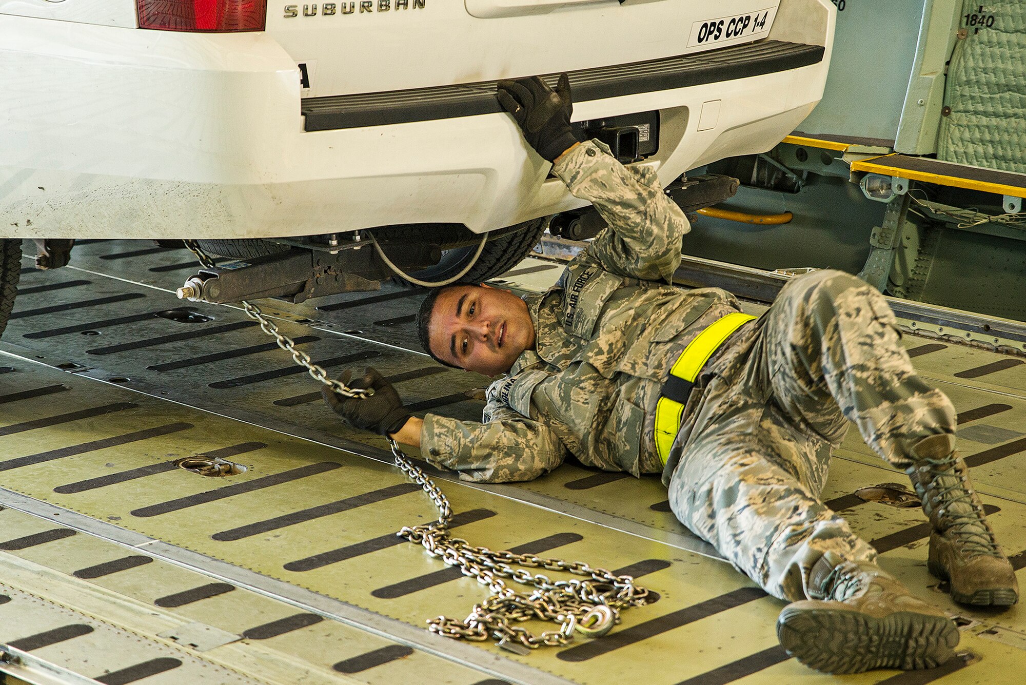 Master Sgt. Alejandro Molina, 733rd Training Squadron air transportation specialist, secures chains to the undercarriage of a U.S. Army North Task Force 51 emergency response vehicle at the 433rd Airlift Wing's C-5 load trainer facility March 2, 2016 at Joint Base San Antonio-Lackland, Texas. Task Force 51 is responsible for overseeing Army reserve and active duty assets  in the event of a chemical, biological, radiological, nuclear, and explosives attack on U.S. soil.  (U.S. Air Force photo by Benjamin Faske) (released)