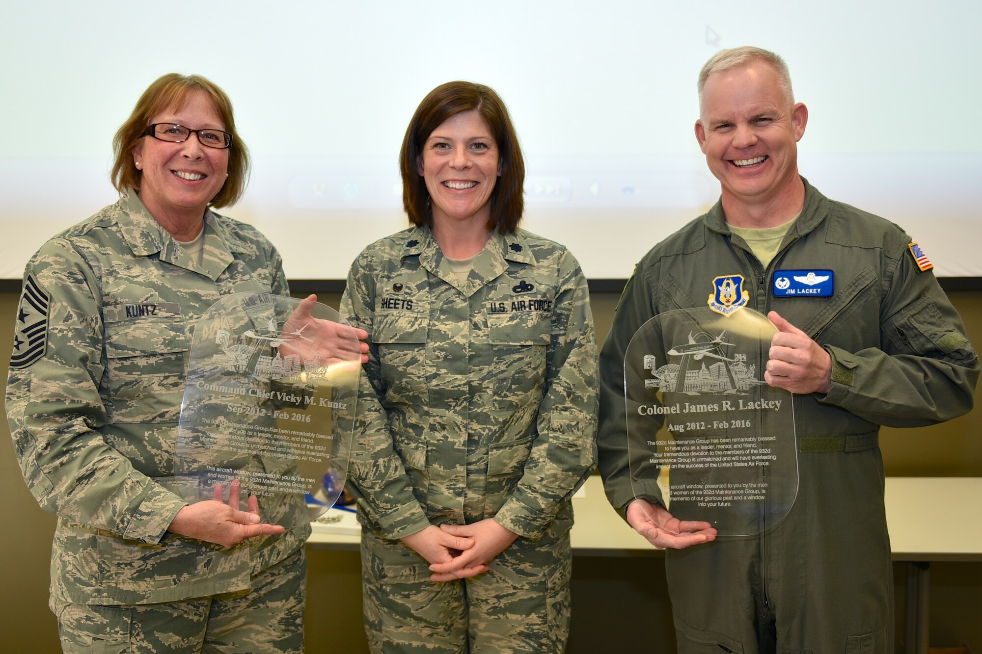 Commander of the 932nd Maintenance Group, Lt. Col. Amanda Sheets (center), presented commemorative C-40C replica service windows documenting the wing leadership times of both outgoing Command Chief Master Vicky Sgt. Kuntz (left), and the outgoing vice commander Col. James Lackey (right).  (U.S. Air Force photo by Tech. Sgt. Christopher Parr)
