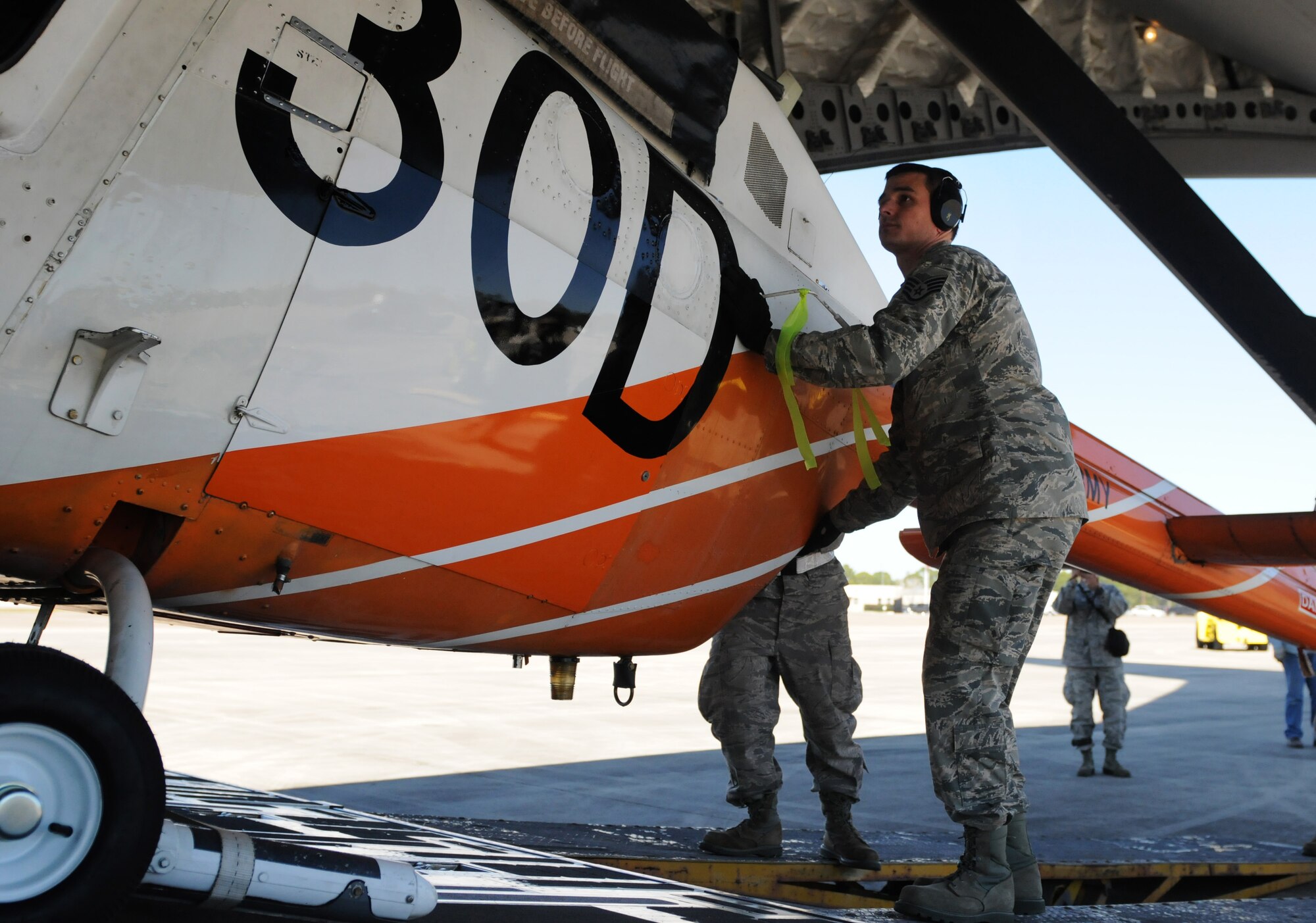 Staff Sgt. Jeremy Bean, an air transportation specialist with the 41st Aerial Port Squadron, an Air Force Reserve unit at Keesler Air Force Base, Mississippi, loads a helicopter into a C-17 Globemaster at the Combat Readiness Training Center, Gulfport, Mississippi, Feb. 26, 2016. The Airmen and Soldiers loaded the helicopters for shipping to Columbia for Columbian Air Force helicopter training. (U.S. Air Force photo/Senior Airman Holly Mansfield)