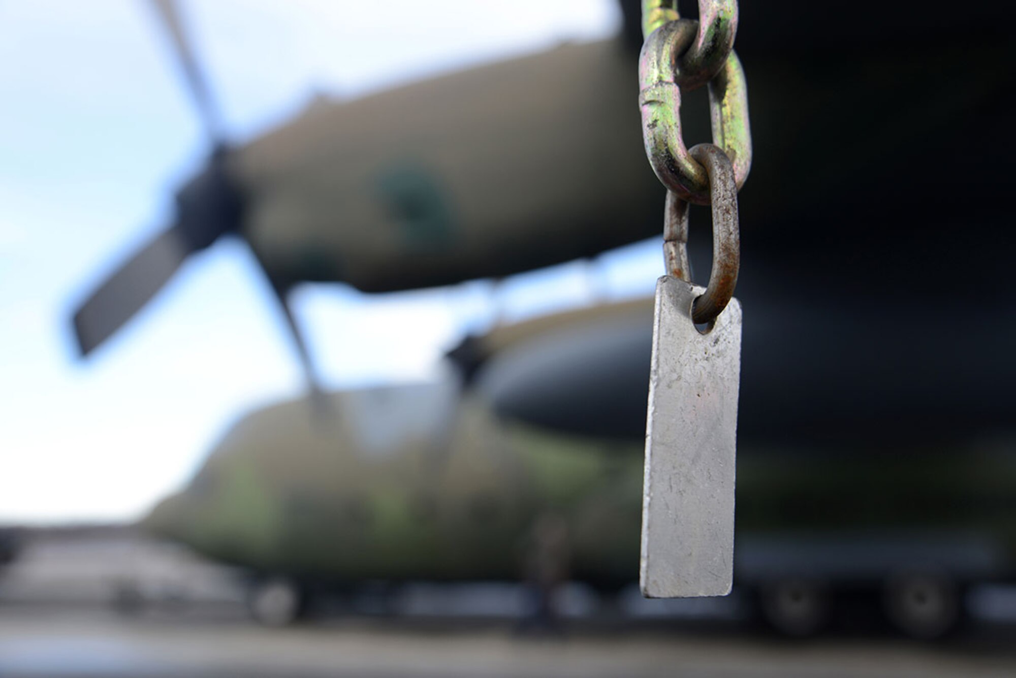 A chain hangs from a wing of the C-130 Hercules as it is towed at Joint Base Elmendorf-Richardson Feb. 27, 2016. The aircraft has been towed to Hangar 21 for refurbishment and is scheduled to return to Heritage Park in April. (U.S. Air Force photo by Airman 1st Class Christopher R. Morales)