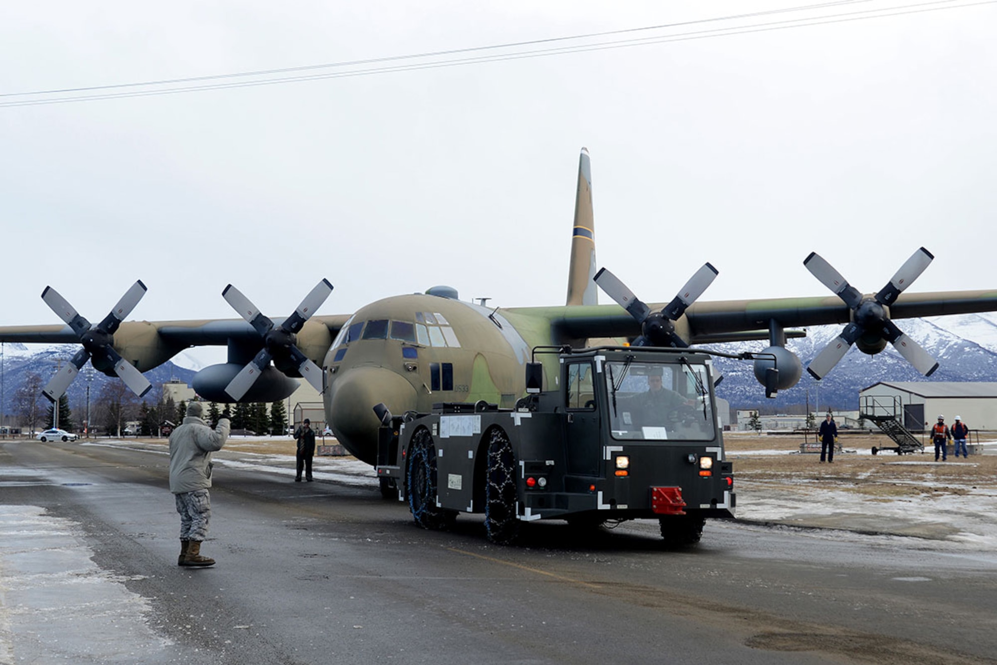 Airmen and contracted personnel work together to tow the static C-130 Hercules at Joint Base Elmendorf-Richardson Feb. 27, 2016. The aircraft was towed to Hangar 21 for refurbishment and is scheduled to return to Heritage Park in April. (U.S. Air Force photo by Airman 1st Class Christopher R. Morales)