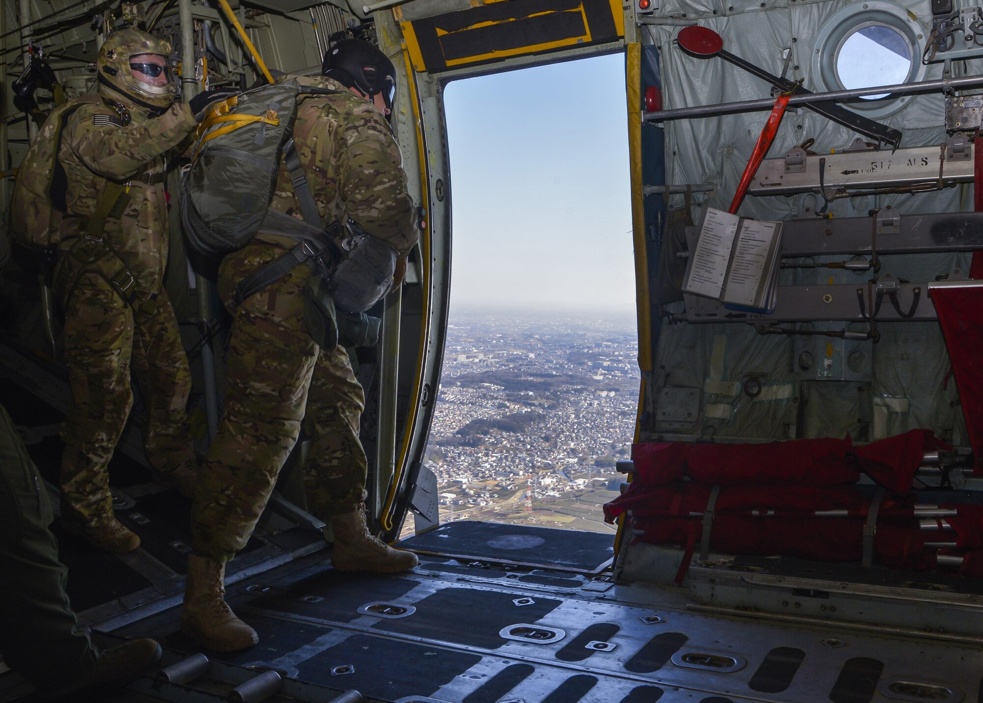 Staff Sgt. Justin Bender, 374th Operations Support Squadron survival, evasion, resistance and escape training NCO in charge, prepares to jump out of a C-130 Hercules while flying over Yokota Air Base, Japan, March 2, 2016. The training not only allowed the SERE personnel to practice jumping, it helped loadmasters and other aircrew members perform personnel drop training. (U.S. Air Force photo by Senior Airman David Owsianka/Released)