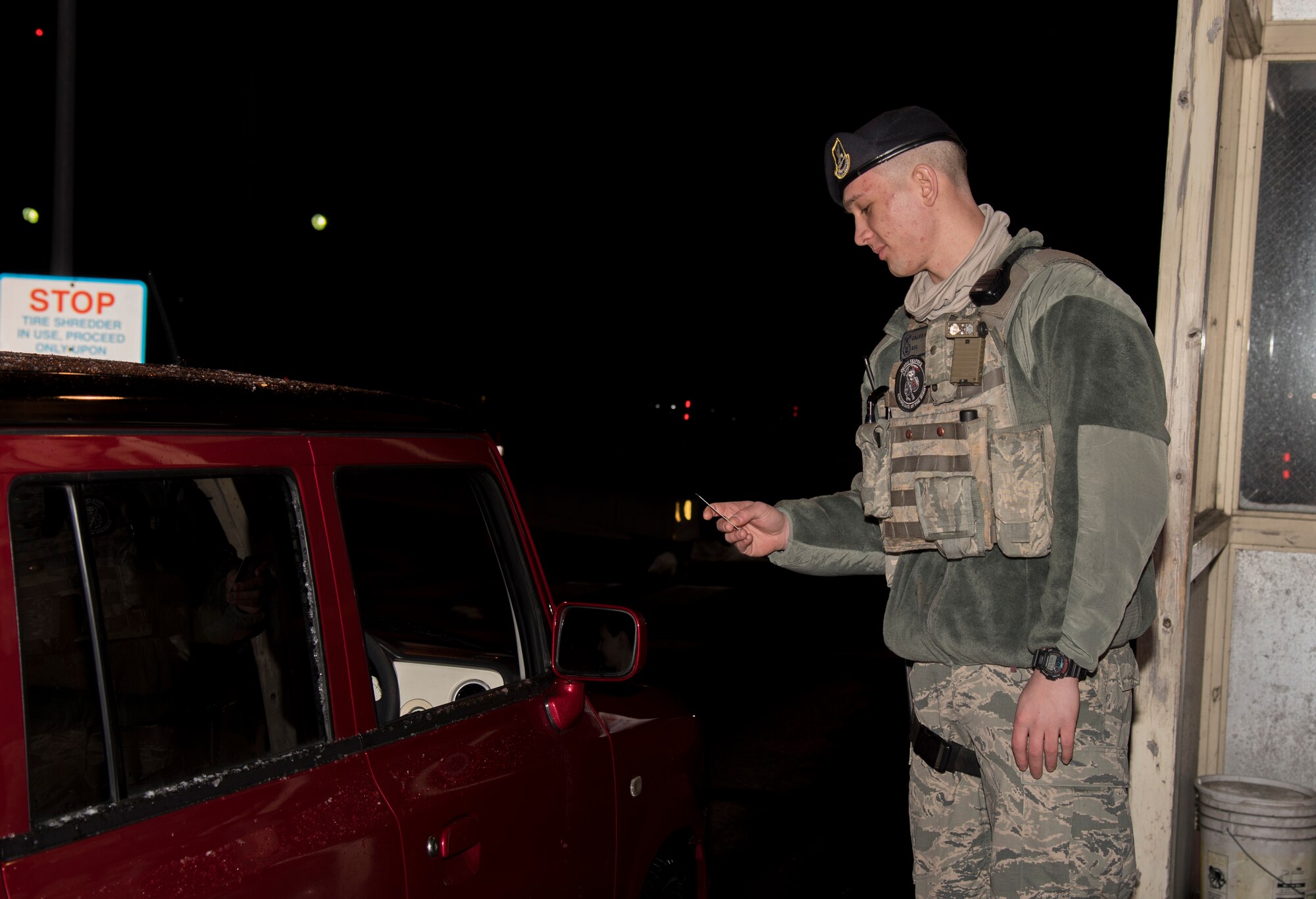 U.S. Air Force Airman 1st Class Caleb Kenley, a security response team member and installation entry controller with the 35th Security Forces Squadron, checks an identification card at Misawa Air Base, Japan, March 1, 2016. Kenley's daily mission is to safeguard personnel and property, as well as to provide security to the protection level resources on Misawa AB. (U.S. Air Force photo by Senior Airman Brittany A. Chase)