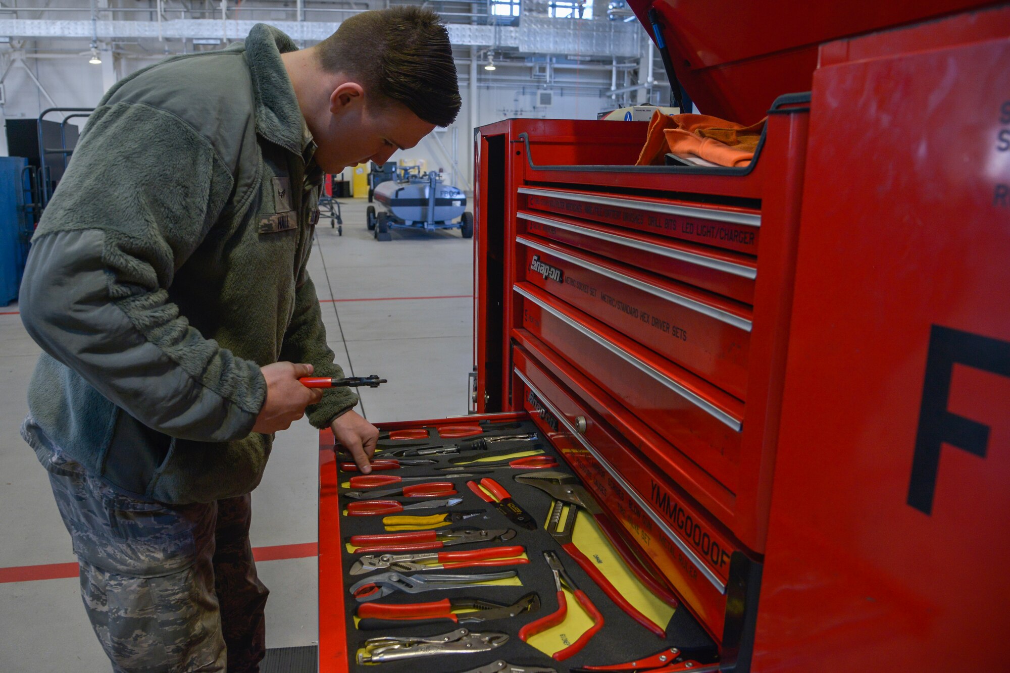 Airman 1st Class Harley Hall, 374th Maintenance Squadron Aerospace Ground Equipment mechanic, takes tools out of the toolbox to perform maintenance on a servicing cart at Yokota Air Base, Japan, Feb. 11, 2016. The AGE flight maintains, services and repairs 408 assets that support the base’s mission. (U.S. Air Force photo by Senior Airman David Owsianka/Released)