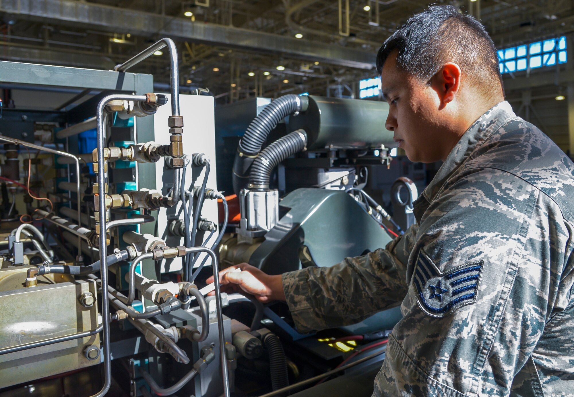 Staff Sgt. Arden Roldan, 374th Maintenance Squadron Aerospace Ground Equipment craftsman, inspects for damaged areas on a diesel generator at Yokota Air Base, Japan, Feb. 11, 2016. The AGE flight is split into five sections: programs, production support, inspections, maintenance and war reserve materials. (U.S. Air Force photo by Senior Airman David Owsianka/Released)