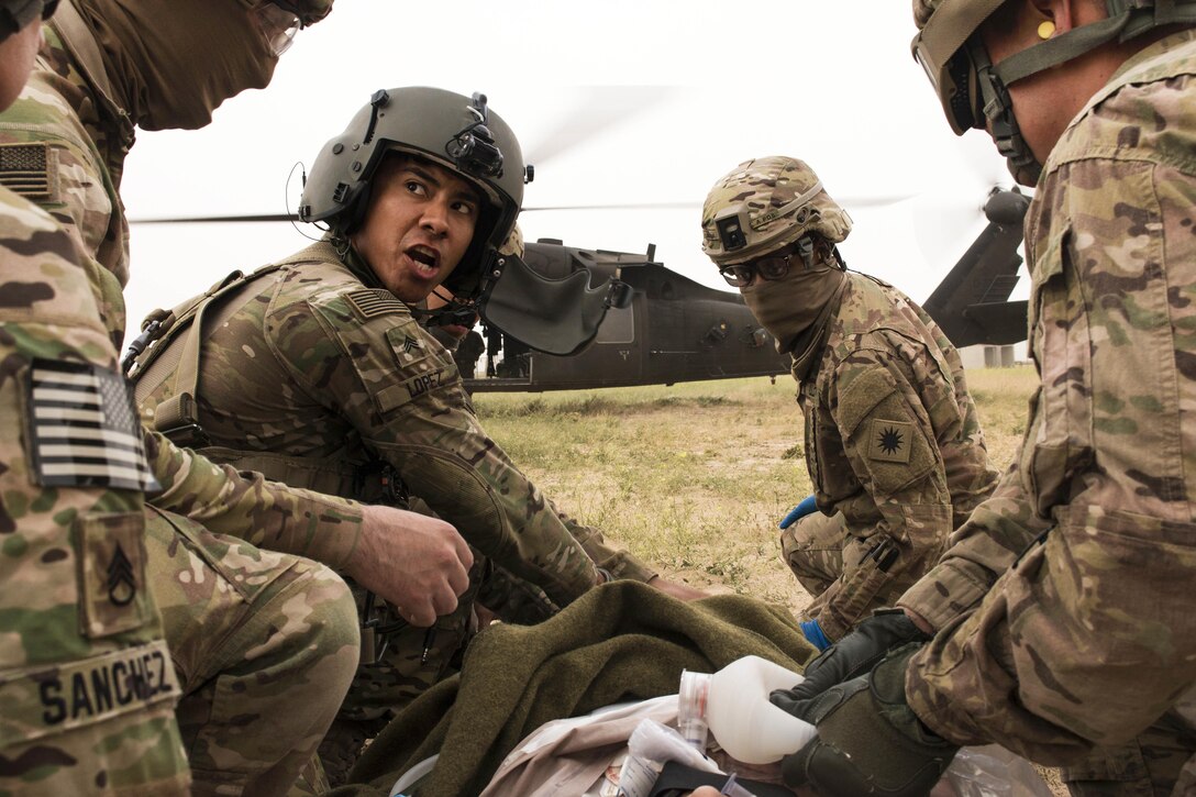 Army Sgt. Lopez, center left, gives directions to fellow soldiers as they prepare to evacuate simulated casualties on a UH-60 Black Hawk helicopter on Camp Buehring, Kuwait, Feb. 23, 2016. Lopez is a crew chief assigned to Company F, 2nd Battalion, 238th Aviation Regiment, 40th Combat Aviation Brigade. Army photo by Staff Sgt. Ian M. Kummer