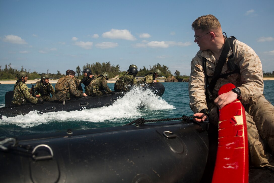 Cpl. Lionel Armstrong observes while members of the Japanese Ground Self-Defense Force navigate the seas in a Combat Rubber Raiding Craft at Kin Blue, Okinawa, Japan, March 3, 2016. The JGSDF members watched the Marines perform raid missions and navigate using a nautical compass. Armstrong, from Richland, Michigan, is a safety swimmer with 3rd Reconnaissance Battalion, 3rd Marine Division, III Marine Expeditionary Force. (U.S. Marine photo by Cpl. Robert Williams Jr./Released)