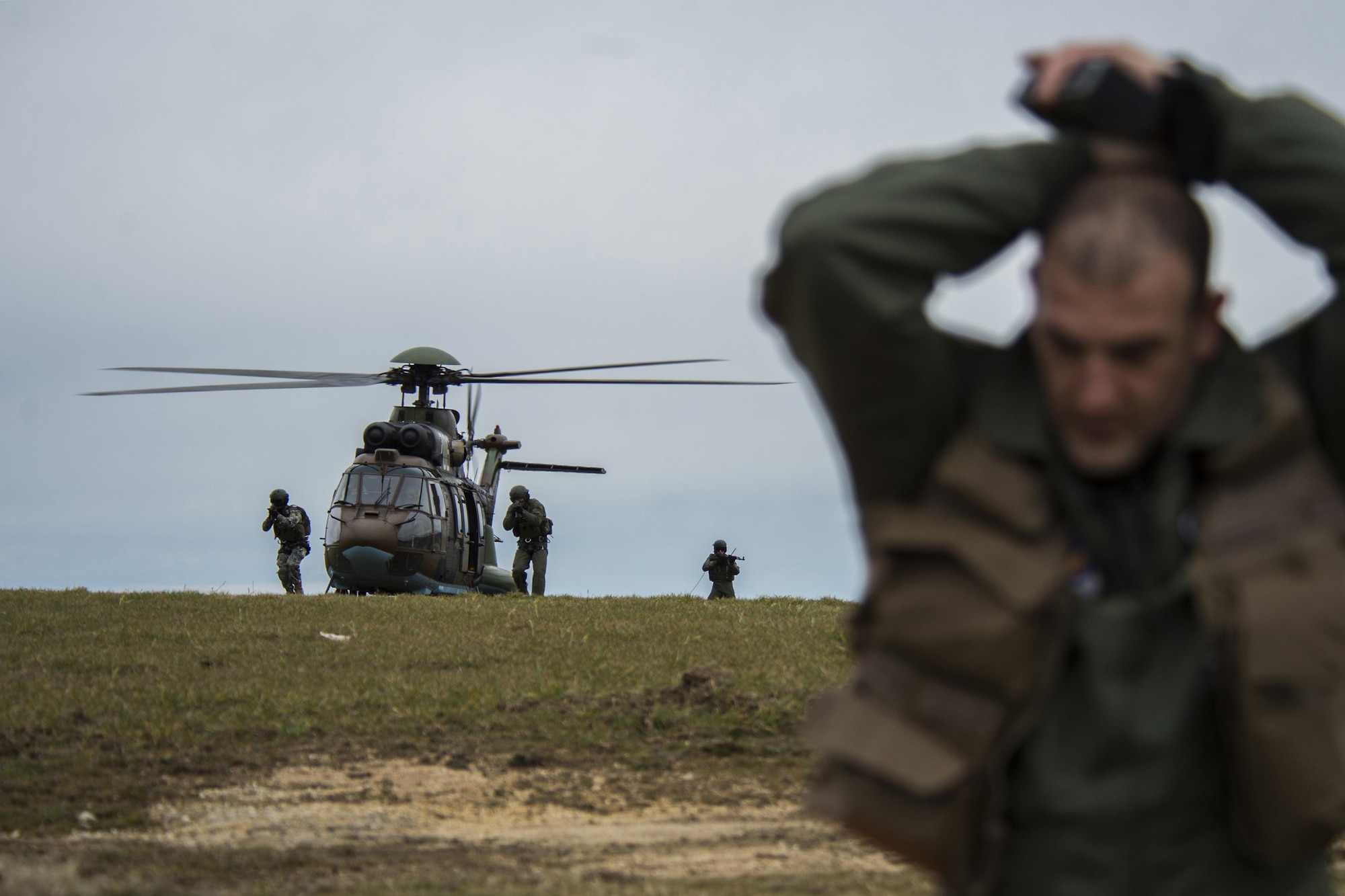 PLOVDIV, Bulgaria - Members of the Bulgarian Special Forces exit a Bulgarian AS-532 Cougar helicopter and move toward Italian air force Captain Roberto Manzo, a 74th Expeditionary Fighter Squadron A-10C Thunderbolt II aircraft exchange pilot, during combat search and rescue training near Plovdiv, Bulgaria, Feb. 11, 2016. The Special Forces had to verify that Manzo is the correct person they are looking for before extracting him. (U.S. Air Force photo by Airman 1st Class Luke Kitterman/Released)