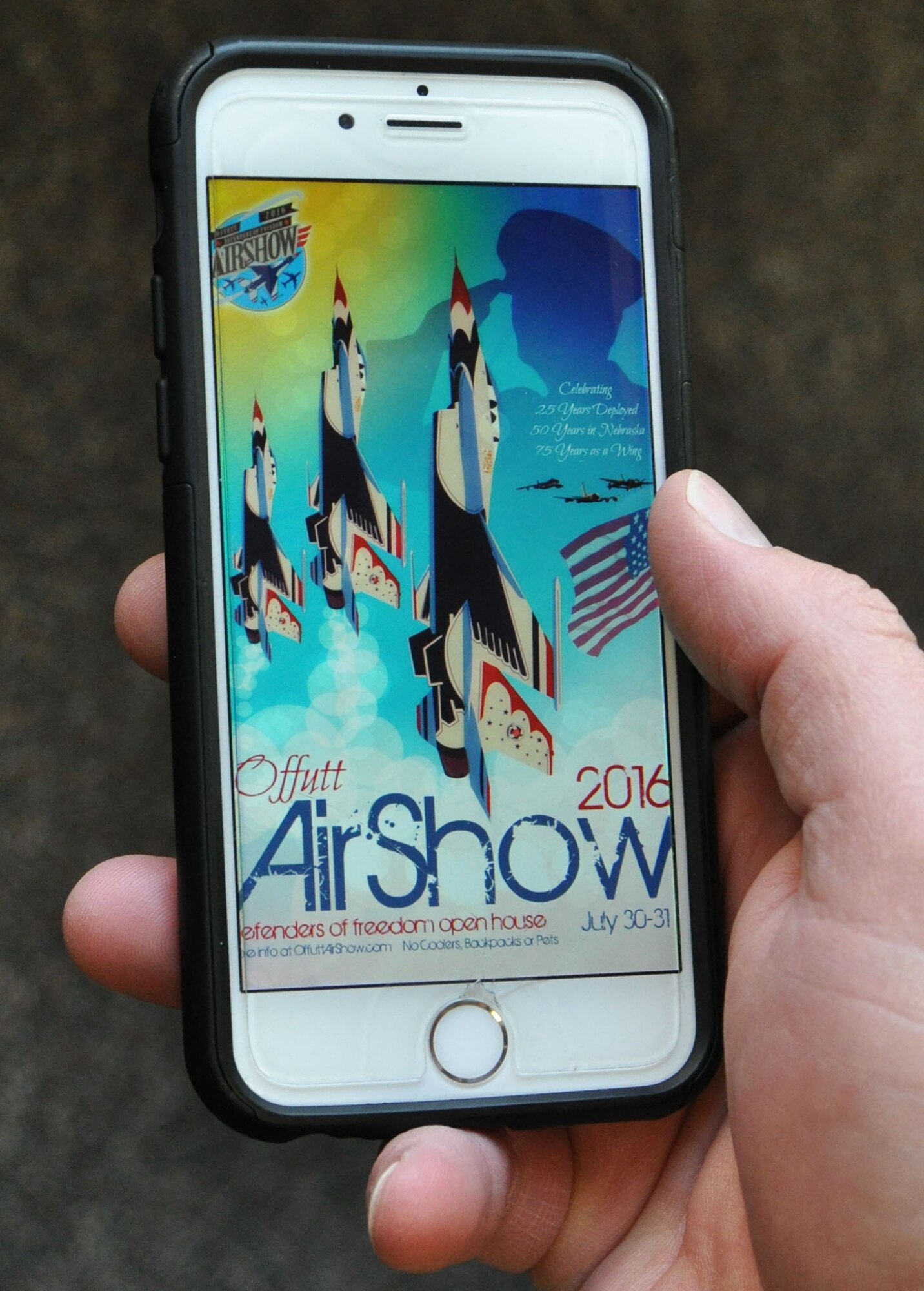 The 2016 Defenders of Freedom Open House and Air Show poster is projected full-screen on a smart phone March 3, 2016 on Offutt Air Force Base, Neb. The air show planners are scheduled to roll-out a brand new application in June which will feature maps, directions, parking and much more.