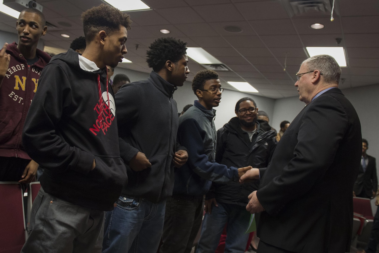 Deputy Defense Secretary Bob Work presents his challenge coin to students from the Dayton, Ohio, area after speaking to them about technology and the Defense Department as part of a 'Week at the Labs" event at Wright-Patterson Air Force Base, Ohio, March 3, 2016. DoD photo by Air Force Senior Master Sgt. Adrian Cadiz