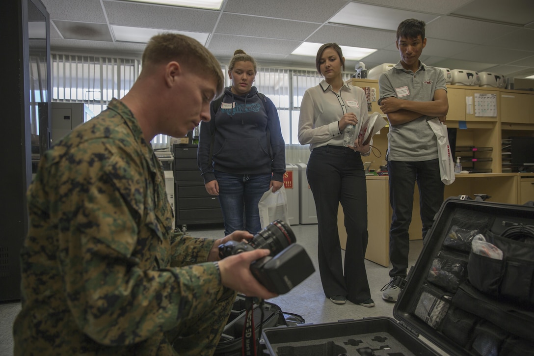 Lance Cpl. Eric Clayton, combat photographer, Headquarters Battalion, mentors Twentynine Palms High School students who have an interest in becoming photographers during the 13th annual Job Shadowing Event aboard the Combat Center Feb. 23, 2016. The event began as a partnership between the Morongo Unified School District and the installation and provides students with insight on potential careers. (Official Marine Corps photo by Lance Cpl. Levi Schultz/Released)