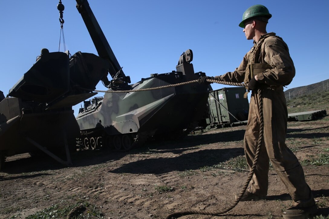 A Marine removes a heavily armored engine cover from an Amphibious Assault Vehicle in order to conduct maintenance on the engine during a Marine Corps Combat Readiness Evaluation Feb. 24, 2016. The MCCRE evaluates the readiness of the Marines of Company A, 3rd Assault Amphibian Battalion prior to their deployment to Okinawa, Japan. Marines in the maintenance section are also tested during the MCCRE along with the AAV-7 crew. (U.S. Marine Corps photo by Lance Cpl. Timothy Valero/ Released)
