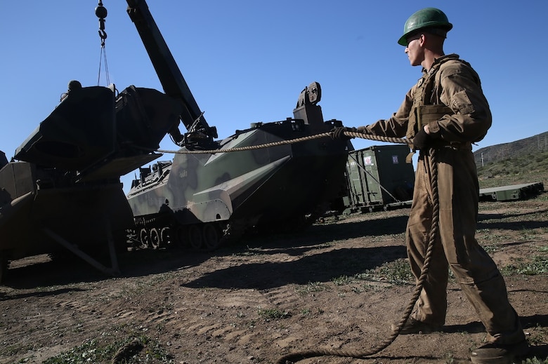 A Marine removes a heavily armored engine cover from an Amphibious Assault Vehicle in order to conduct maintenance on the engine during a Marine Corps Combat Readiness Evaluation Feb. 24, 2016. The MCCRE evaluates the readiness of the Marines of Company A, 3rd Assault Amphibian Battalion prior to their deployment to Okinawa, Japan. Marines in the maintenance section are also tested during the MCCRE along with the AAV-7 crew. (U.S. Marine Corps photo by Lance Cpl. Timothy Valero/ Released)
