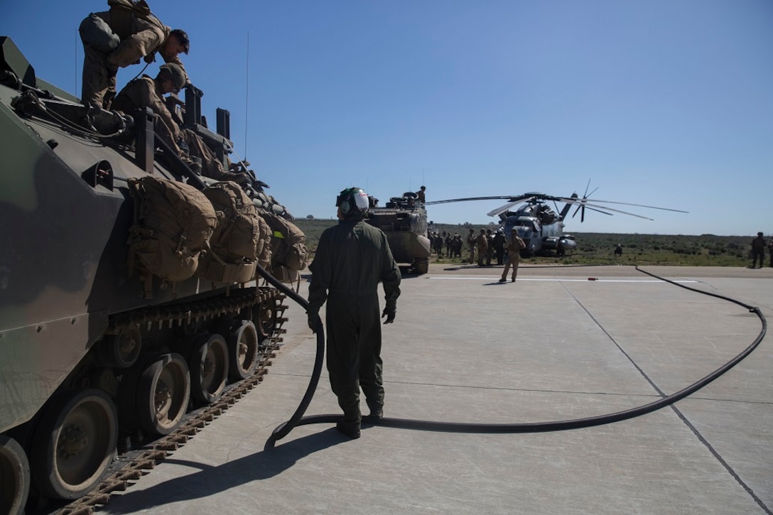 Marines refuel an Amphibious Assault Vehicle from a CH-53E Super Stallion during a Marine Corps Combat Readiness Evaluation Feb. 25, 2016. The MCCRE evaluates the readiness of the Marines of Company A, 3rd Assault Amphibian Battalion prior to their deployment to Okinawa, Japan. Refueling from an aircraft is a unique capability for the AAV crew as it is not a commonly trained skill. The aircraft is from Marine Heavy Helicopter Squadron 465, 3rd Marine Aircraft Wing. (U.S. Marine Corps photo by Lance Cpl. Timothy Valero/ Released)