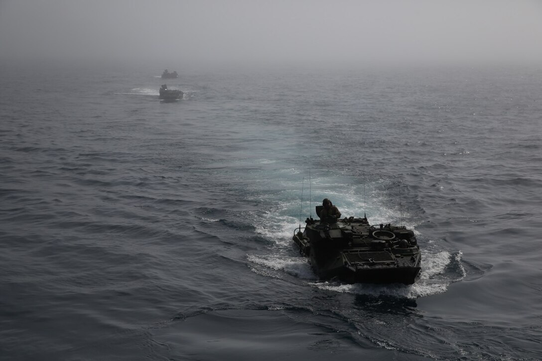 Assault Amphibious Vehicles break through the fog to arrive at the well deck of the USS Essex (LHD 2) off the coast of Camp Pendleton Feb. 23, 2016. The beach assault was part of the Marine Corps Combat Readiness Evaluation of Company A, 3rd Assault Amphibian Battalion, 1st Marine Division. (U.S. Marine Corps photo by Lance Cpl. Timothy Valero/Released)
