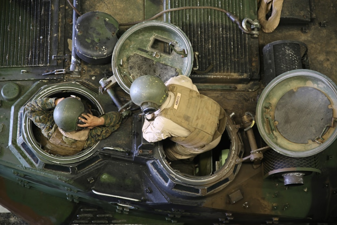 Lance Cpl. Faris Abbassi, right, communicates with his driver after embarking on the USS Essex (LHD 2) off the shore of Camp Pendleton Feb. 23, 2016. Marines conducted a Marine Corps Combat Readiness Evaluation to test the unit’s readiness for its upcoming deployment. Abbassi is a crewman with Company A, 3rd Assault Amphibian Battalion, 1st Marine Division and is from Dallas, Texas. (U.S. Marine Corps photo by Lance Cpl. Timothy Valero/ Released)