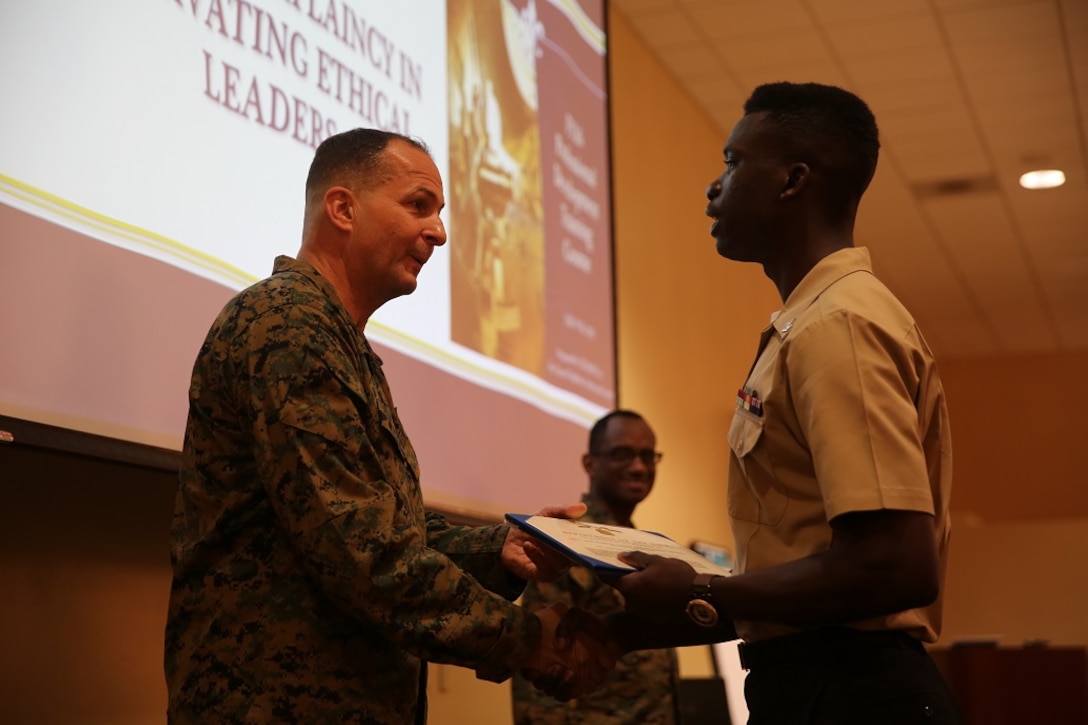 Maj. Gen. Daniel J. O'Donohue presents the Naval Chaplaincy Excellence award to Petty Officer 3rd Class Dawaylon Farr at Camp Pendleton, Feb. 23, 2016. The ceremony recognized Lt. Michael Kennedy and Petty Officer 3rd Class Dawaylon Farr for going above and beyond the call of duty to provide spiritual guidance and renewed faith to Marines and sailors serving I Marine Expeditionary Force. O’Donohue, the commanding general of 1st Marine Division, was a guest speaker and presented awards to the recipients.  Kennedy is a chaplain with 1st Battalion, 1st Marine Regiment, 1st Mar. Div. Farr is a religious program specialist with 1st Bn., 4th Marines. (U.S. Marine Corps photo by Pvt. Robert Bliss/Released)