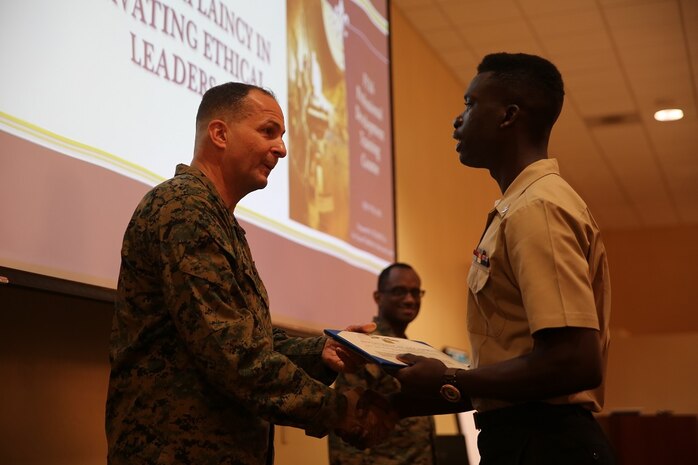 Maj. Gen. Daniel J. O'Donohue presents the Naval Chaplaincy Excellence award to Petty Officer 3rd Class Dawaylon Farr at Camp Pendleton, Feb. 23, 2016. The ceremony recognized Lt. Michael Kennedy and Petty Officer 3rd Class Dawaylon Farr for going above and beyond the call of duty to provide spiritual guidance and renewed faith to Marines and sailors serving I Marine Expeditionary Force. O’Donohue, the commanding general of 1st Marine Division, was a guest speaker and presented awards to the recipients.  Kennedy is a chaplain with 1st Battalion, 1st Marine Regiment, 1st Mar. Div. Farr is a religious program specialist with 1st Bn., 4th Marines. (U.S. Marine Corps photo by Pvt. Robert Bliss/Released)