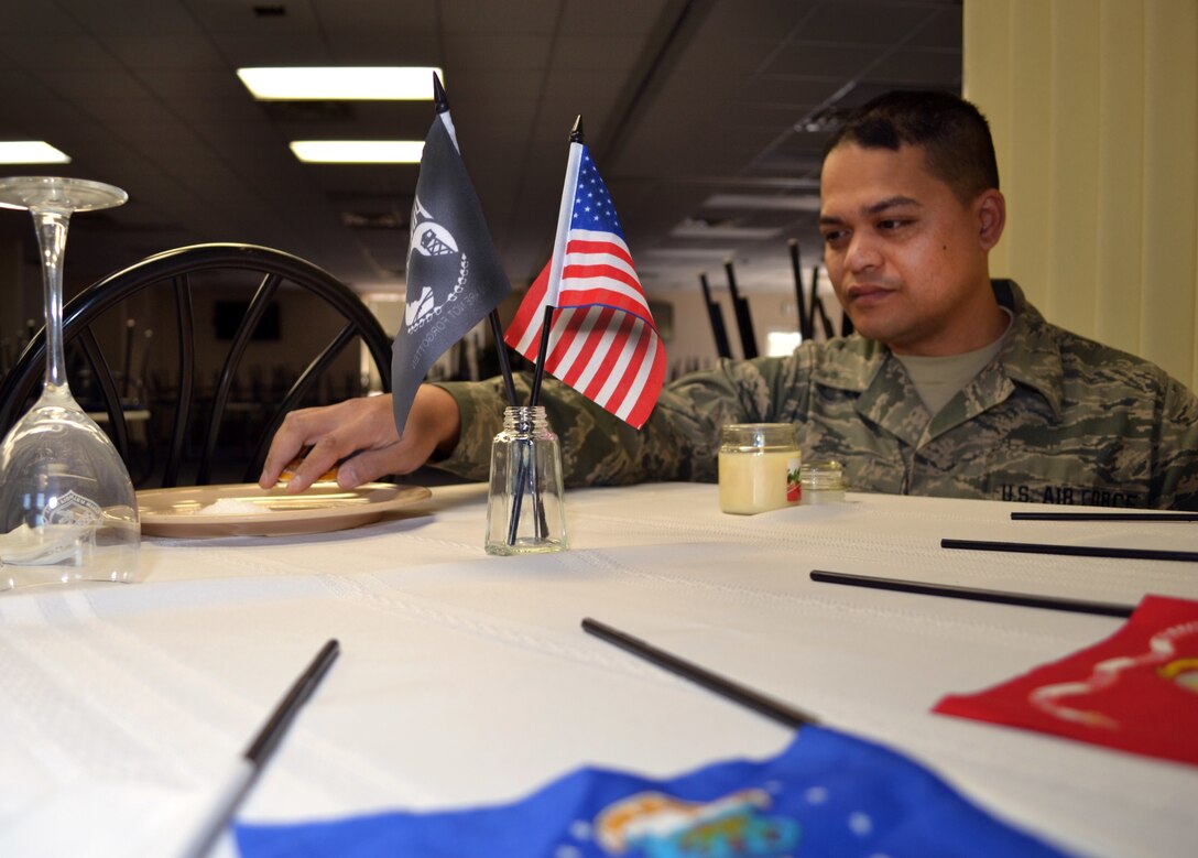 Air Force Senior Airman Alan Phe of the Pennsylvania Air National Guard’s 111th Force Support Squadron Service Flight on Horsham Air Guard Station, Pa., removes the lemon slice from the bread plate of the prisoners of war/missing in action table he created recently at the station’s dining facility, Feb. 22, 2016. U.S. Air Force photo by Tech. Sgt. Andria Allmond