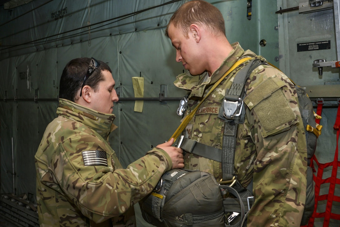 Air Force Tech. Sgt. Benjamin Jonas, left, performs a pre-jump inspection on Air Force Staff Sgt. Justin Bender on Yokota Air Base, Japan, March 2, 2016. Jonas and Bender, noncommissioned officers in charge of survival, evasion, resistance and escape operations, assigned to the 374th Operations Support Squadron, participated in static line, high altitude, and low opening jumps with parachutes in order to maintain their qualifications on different types of jumps. Air Force photo by Senior Airman David Owsianka
