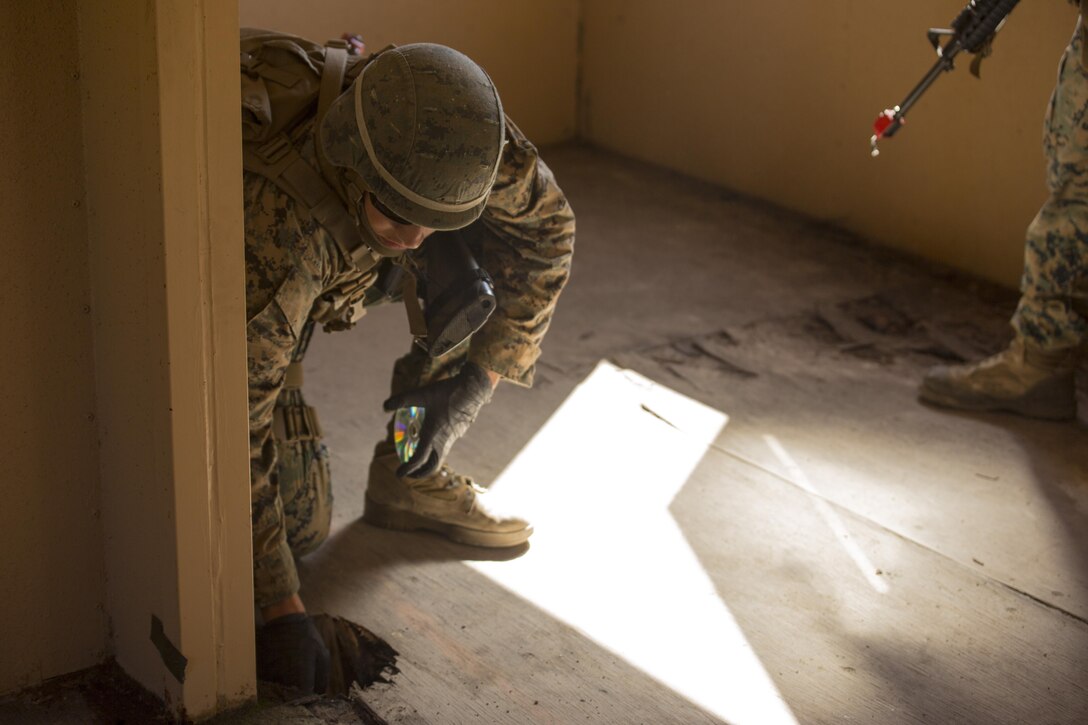 A Marine with 2nd Law Enforcement Battalion locates a DVD during Tactical Site Exploitation training at Camp Lejeune, N.C., March 3, 2016. After raiding the building, the Marines thoroughly searched the area using forensics technology to discover evidence that can help identify who owned the material. (U.S. Marine Corps photo by Lance Cpl. Samuel Guerra/Released)