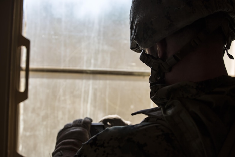 Lance Cpl. Dylan Tucker, military policeman for Bravo Company, 2nd Law Enforcement Battalion, photographs evidence at a crime scene during Tactical Site Exploitation training at Camp Lejeune, N.C., March 4, 2016. In the event Marines depart the scene without collecting all of the evidence, they can reference the photos to continue analyzing enemy material.  (U.S. Marine Corps photo by Lance Cpl. Samuel Guerra/Released)   