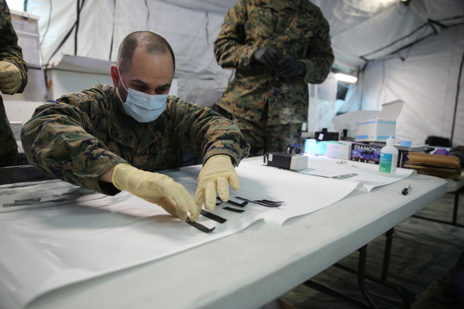 Sgt. Alberto Camacho, military policeman for Charlie Company, 2nd Law Enforcement Battalion, separates evidence without fingerprints during Tactical Site Exploitation training at Camp Lejeune, N.C., March 3, 2016. The training emphasizes the importance of leaving the evidence in pristine condition to ensure they get the most accurate intelligence necessary to identify the enemies. (U.S. Marine Corps photo by Lance Cpl. Samuel Guerra/Released)