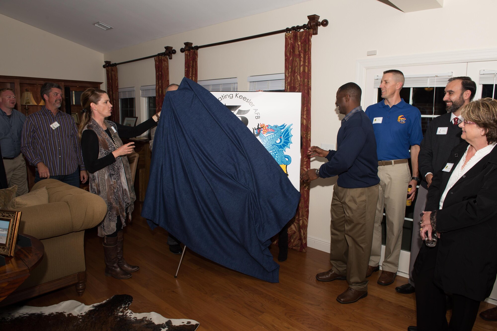 Col. Michele Edmondson, 81st Training Wing commander, and Chief Master Sgt. Harry Hutchinson, 81st TRW command chief, unveil Keesler’s 75th Anniversary logo during the honorary commander reception and induction ceremony Feb. 26, 2016, Keesler Air Force Base, Miss. Edmondson also presented a certificate to each of the newly appointed honorary commanders.