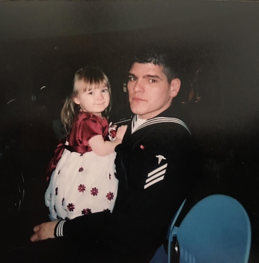 HM1(FMF) Manuel Reyes, medical group chief with Headquarters Squadron, Marine Aircraft Group 49, 4th Marine Aircraft Group, Marine Forces Reserve, poses for a picture with his daughter during his Hospital Corpsman School graduation in 2005. Reyes is the active component recipient of the 2015 Marine Forces Reserve Sailor of the Year award. [Courtesy photo by HM1(FMF) Manuel Reyes]