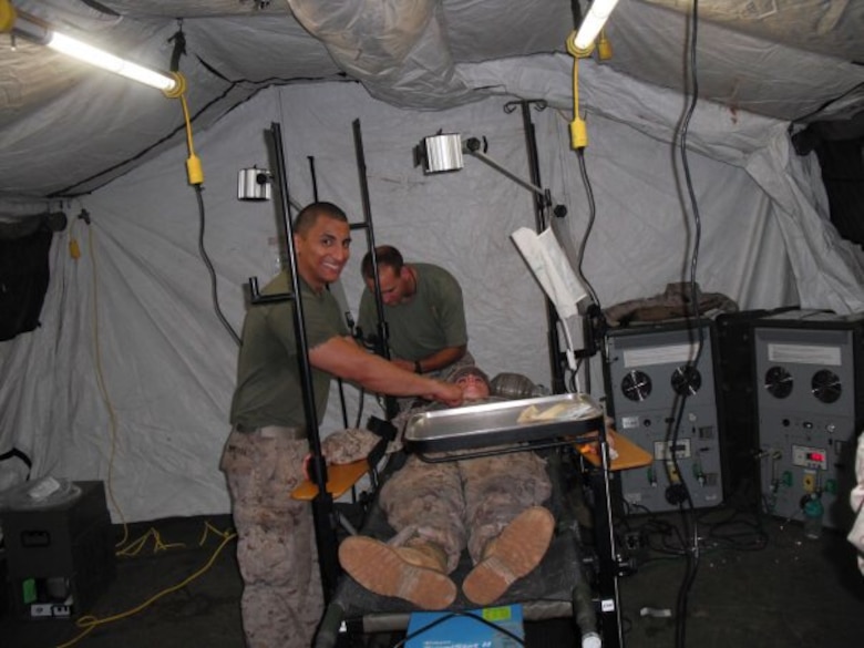 HM1(FMF) Argenis Mendoza (left), leading petty officer of Surgical Company B, 4th Medical Battalion, 4th Marine Logistics Group, Marine Forces Reserve, helps set up and troubleshoot a trauma surgery unit in Benin, Africa, during Operation Shared Accord in July 2010.  Mendoza, a surgical technologist, is the Reserve component recipient of the 2015 Marine Forces Reserve Sailor of the Year award. [Courtesy photo by HM1(FMF) Argenis Mendoza]