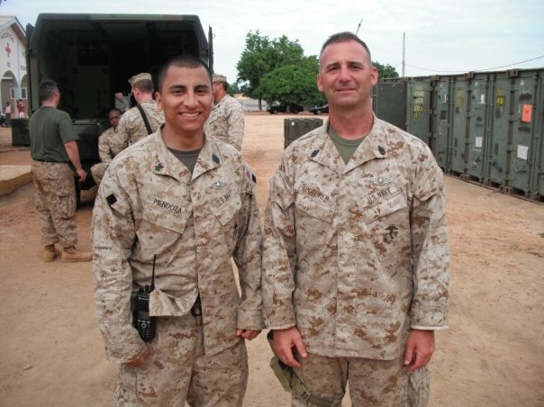 HM1(FMF) Argenis Mendoza (left), leading petty officer with Surgical Company B, 4th Medical Battalion, 4th Marine Logistics Group, Marine Forces Reserve, poses for a picture with his mentor, Senior Chief Petty Officer Barry Potoker, in Benin, Africa, during Operation Shared Accord in July 2010. Mendoza, a surgical technologist, is the Reserve component recipient of the 2015 Marine Forces Reserve Sailor of the Year award. [Courtesy photo by HM1(FMF) Argenis Mendoza]