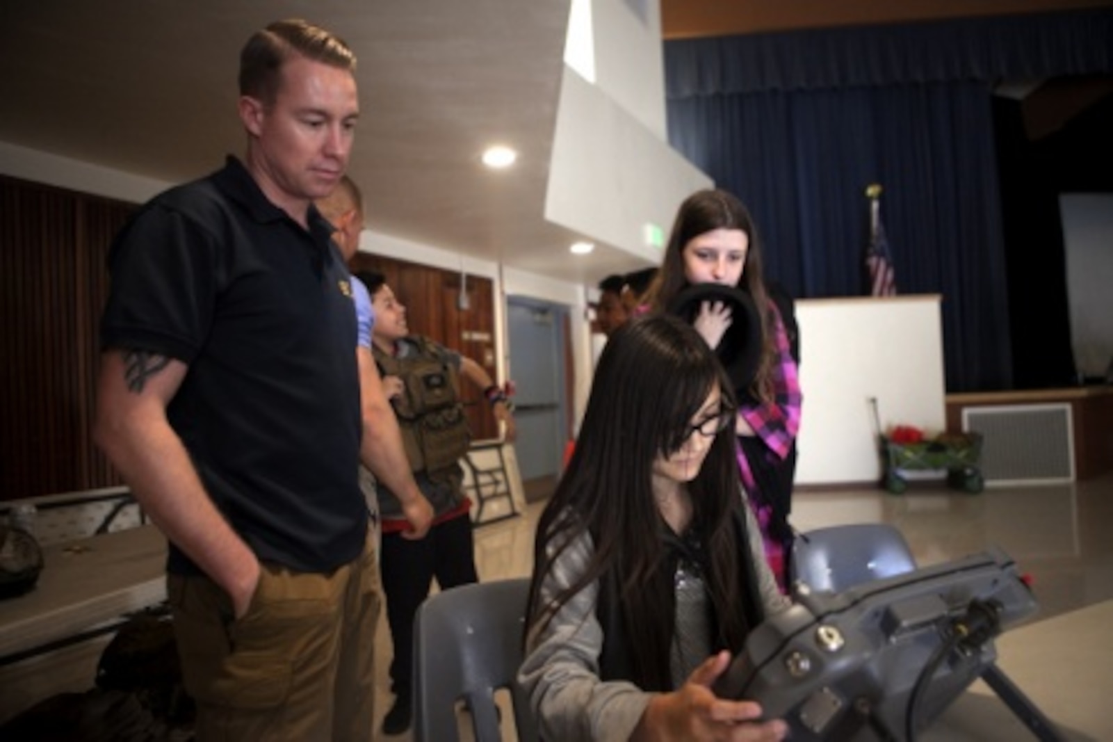Sergeant Craig Matz, an Explosive Ordnance Disposal technician with 1st EOD Company, 7th Engineer Support Battalion, 1st Marine Logistics Group, supervises a James E. Potter Junior High School student attempting to drive the ANDORS EOD robot during a visit to the school in Fallbrook, Calif., Feb. 29, 2016. During the visit, EOD Marines explained the various capabilities of military robots and performed a practical application of EOD’s bomb-detecting robots.