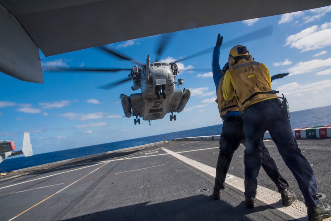 Navy Petty Officers 3rd Class James Ferm and Elliot Salgado signal a CH-53 Sea Stallion to take off from amphibious transport dock ship USS New Orleans in the Pacific Ocean, Feb. 29, 2016. Ferm is an information systems technician and Salgado is an aviation boatswain's mate. The Stallion is assigned to Marine Medium Tilt Squadron 166. Navy photo by Petty Officer 3rd Class Brandon Cyr