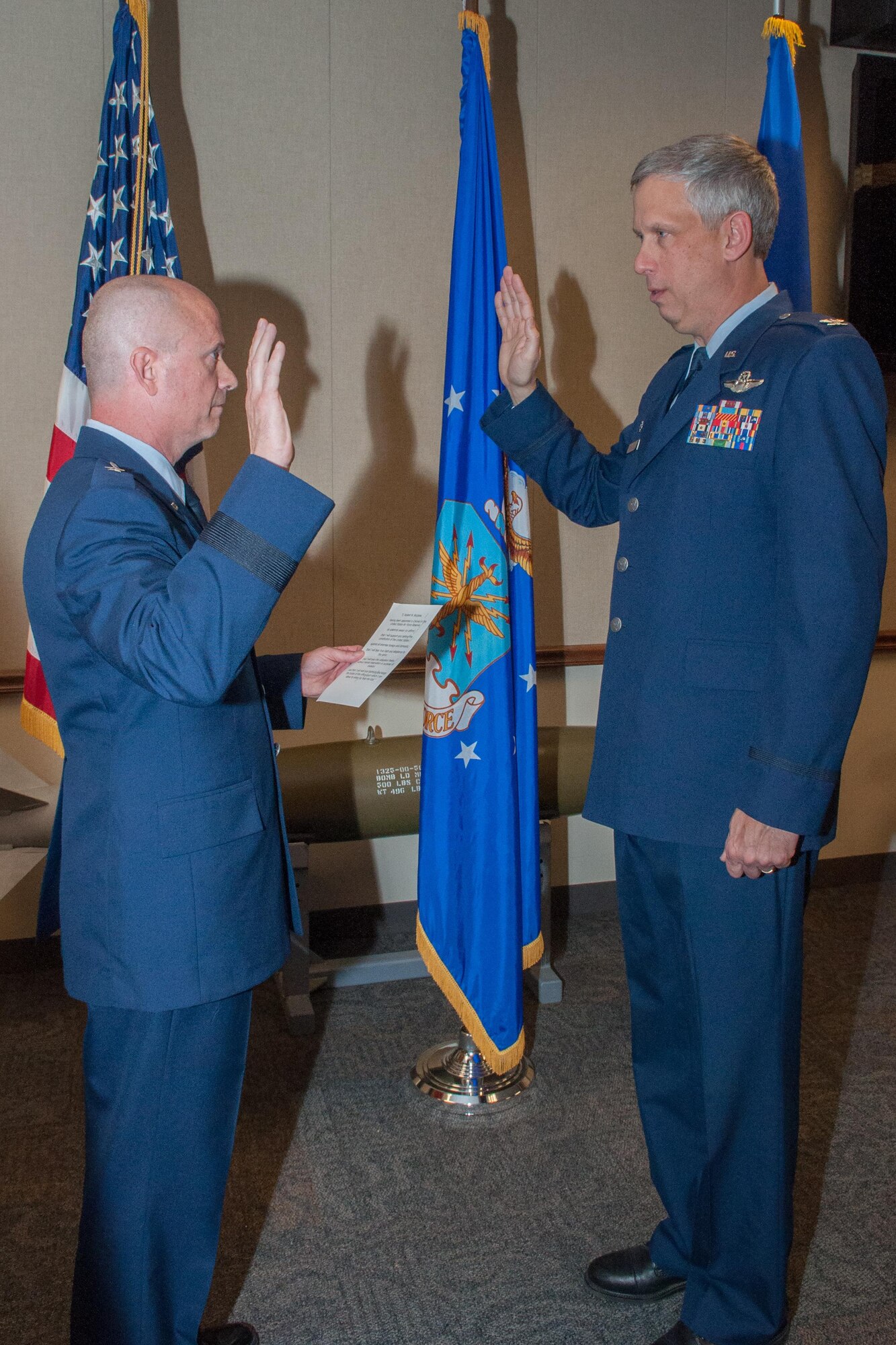 U.S. Air Force Brig. Gen. Jon Ellis, the mobilization assistant to the Director of Operations, Headquarters Air Force Global Strike Command, administers the oath of office to Col. Robert Burgess during a promotion ceremony on Barksdale Air Force Base, La. Burgess is the 307th Operations Group commander and was recently promoted to the rank of colonel. (U.S. Air Force photo by Master Sgt. Dachelle Melville/Released)