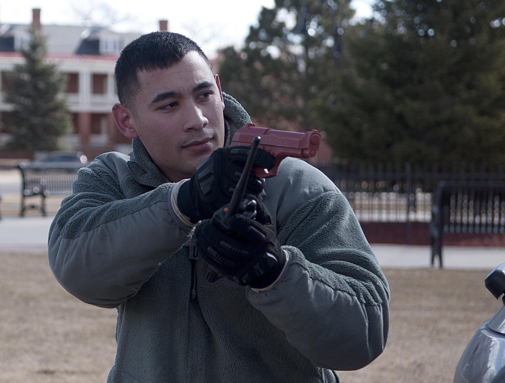 Airman 1st Class Nolan Dofredo, 90th Security Forces Squadron member, provides cover to fellow Airmen as they enter the base theater on F.E. Warren Air Force Base, Wyo., during an active shooter exercise Feb. 29, 2016. The defenders maintained several safety precautions during the exercise, including removing live ammunition and using training weapons. (U.S. Air Force photo by Airman 1st Class Malcolm Mayfield)
