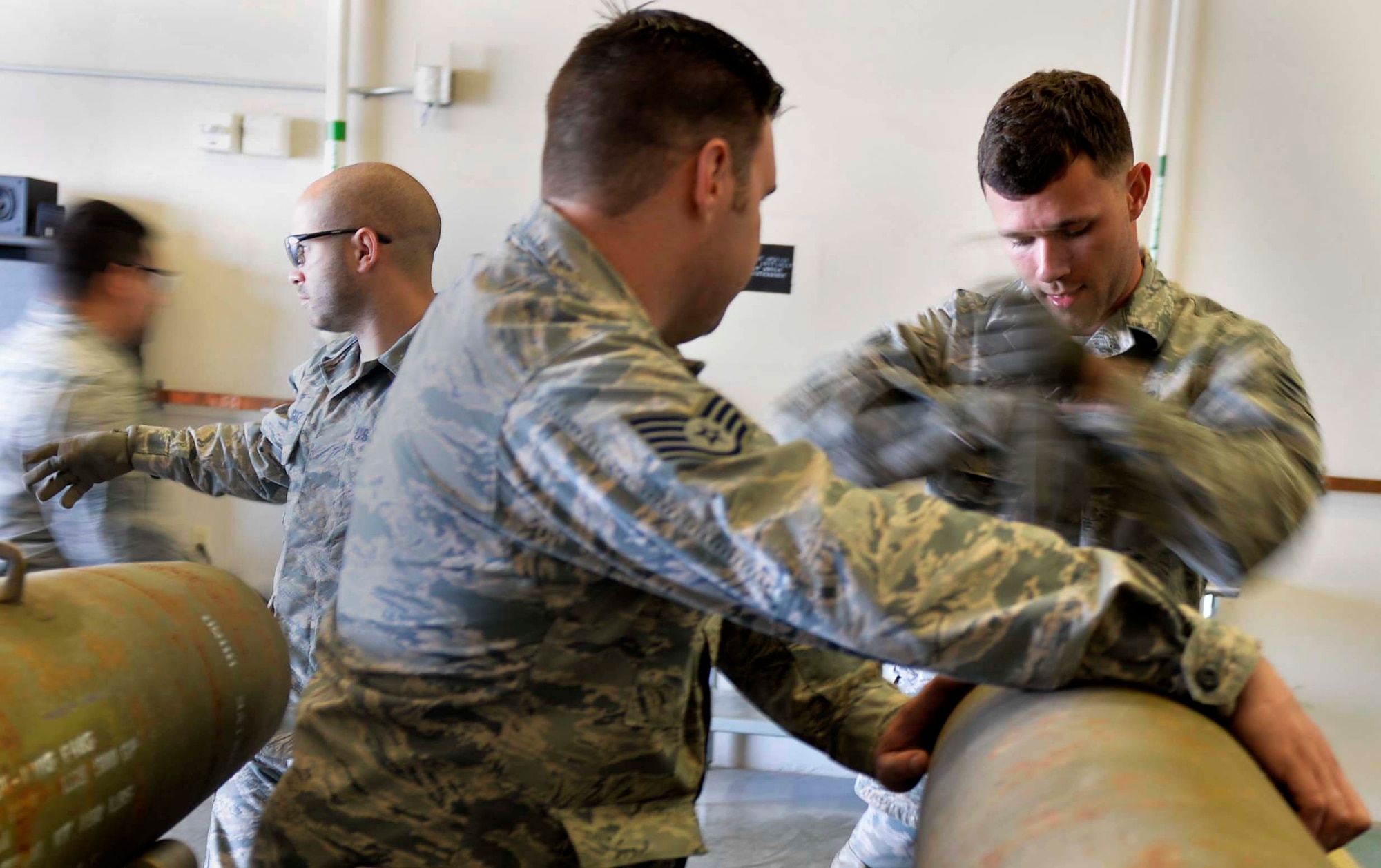 Staff Sgt. Anthony, 432nd Maintenance Squadron munitions flight crew chief, holds a GBU-12 Paveway II laser-guided bomb steady as Senior Airman Joseph, 432nd MXS munitions flight conventional munitions inspector secures a part to the bomb March 1, 2016, at Creech Air Force Base, Nevada. The ammo Airmen stay busy preparing many different types of munitions used to support global contingency operations, as well as managing production, materials, systems, and surveillance of munitions assets. (U.S. Air Force photo by Airman 1st Class Kristan Campbell/Released)