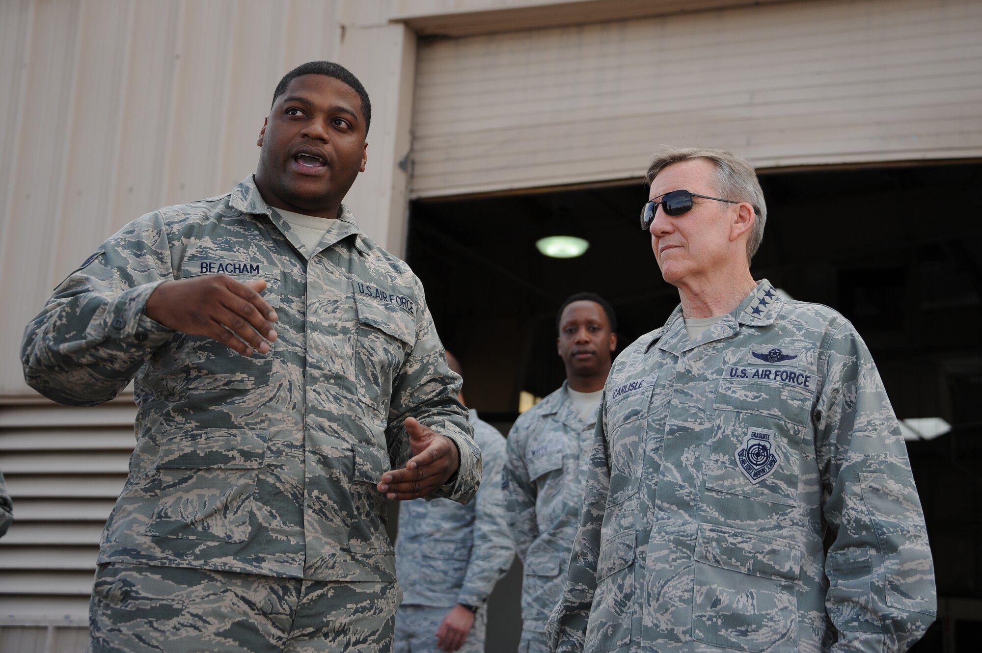 U.S. Air Force Staff Sgt. Booker Beacham III, 355th Equipment Maintenance Squadron aerospace ground equipment, speaks with U.S. Air Force Gen. Hawk Carlisle, commander of Air Combat Command, during a base tour at Davis-Monthan Air Force Base, Ariz., March 3, 2016. Beacham briefed Carlisle on the 355th EMS a unified team of five diverse maintenance flights, Aerospace Ground Equipment Flight, Armament Flight, Fabrication Flight, Maintenance Flight, and Munitions Flight. Carlisle listened as Beacham explained how the squadron was damaged due to flooding during monsoon season. (U.S. Air Force photo by Airman 1st Class Ashley N. Steffen/ Released)