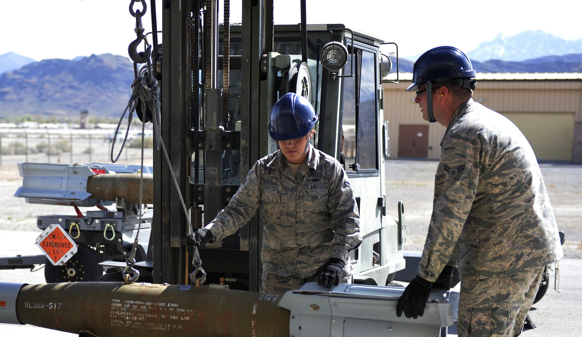 Airman 1st Class Karen and Airman 1st Class Jacob, both Maintenance Squadron munitions flight crew members, participate in a munitions movement March 1, 2016 at Creech Air Force Base, Nevada. Karen and Jacob work in the support section of conventional munitions maintenance, which includes the line delivery program and equipment. (U.S. Air Force photo by Airman 1st Class Kristan Campbell/Released)