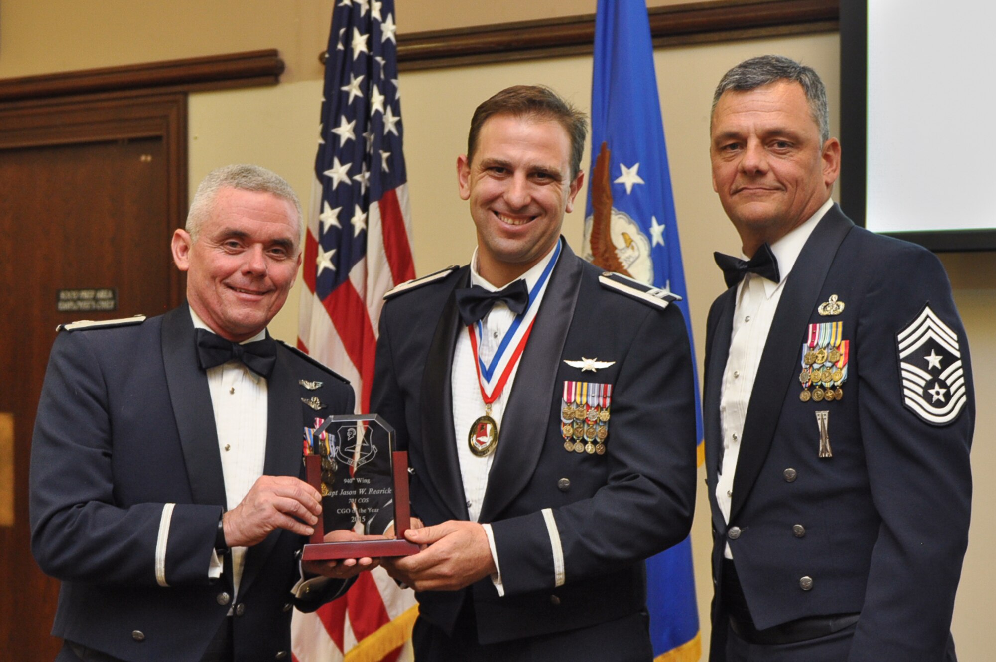 Captain Jason Rearick, 701st Combat Operations Squadron and winner for the Company Grade Officer of the Year annual award is someone who has reflected outstanding leadership in the ranks of lieutenant and captain. He poses with Col. John Trnka, 940th Wing Commander and Chief Master Sgt. Denny Brown, 904th Wing Command Chief at the 2015 940th Wing Dining Out and Annual Awards Banquet. (U.S. Air Force Photo/ Tech. Sgt. Heather Skinkle)     