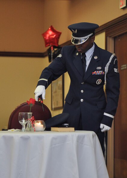 Member of the 9th Reconnaissance Wing Honor Guard lights a candle at the Killed in Action, Prisoners of War, and Missing in Action remembrance ceremony during the 2015 940th Wing Dining Out and Annual Awards Banquet. The lone candle symbolizes the frailty of a prisoner alone, trying to stand up against his or her oppressors. (U.S. Air Force Photo/ Tech. Sgt. Heather Skinkle)  