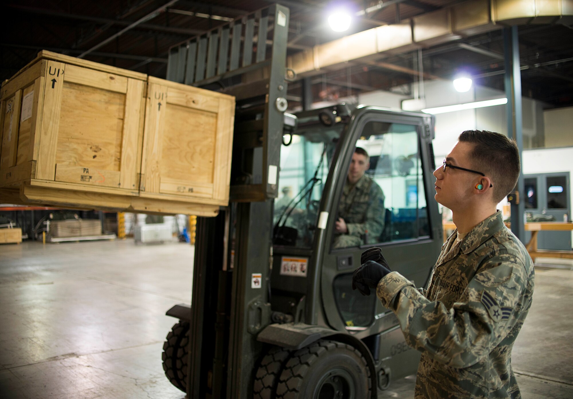 Senior Airman Kyle Metz, 30th Aerial Port Squadron, signals to a forklift operator on Feb. 7, 2016 at the Niagara Falls Air Reserve Station, N.Y. Metz was selected as the 914th Airlift Wing Spotlight performer for February 2016. (U.S. Air Force photo by Tech. Sgt. Stephanie Sawyer) 