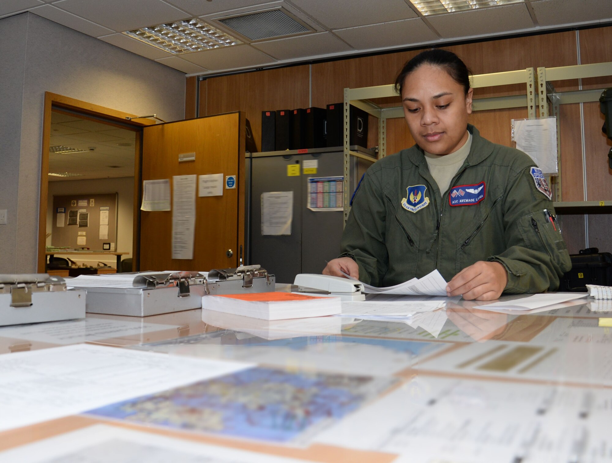 U.S. Air Force Airman 1st Class Avemaoe Liaiga, 351st Air Refueling Squadron boom operator, prepares necessary documents for flight, Feb. 25, 2016, on RAF Mildenhall, England. Liaiga spends around an hour-and-a-half preparing for a mission, followed by a brief of what is going to happen that day during the mission. (U.S. Air Force photo by Gina Randall/Released)