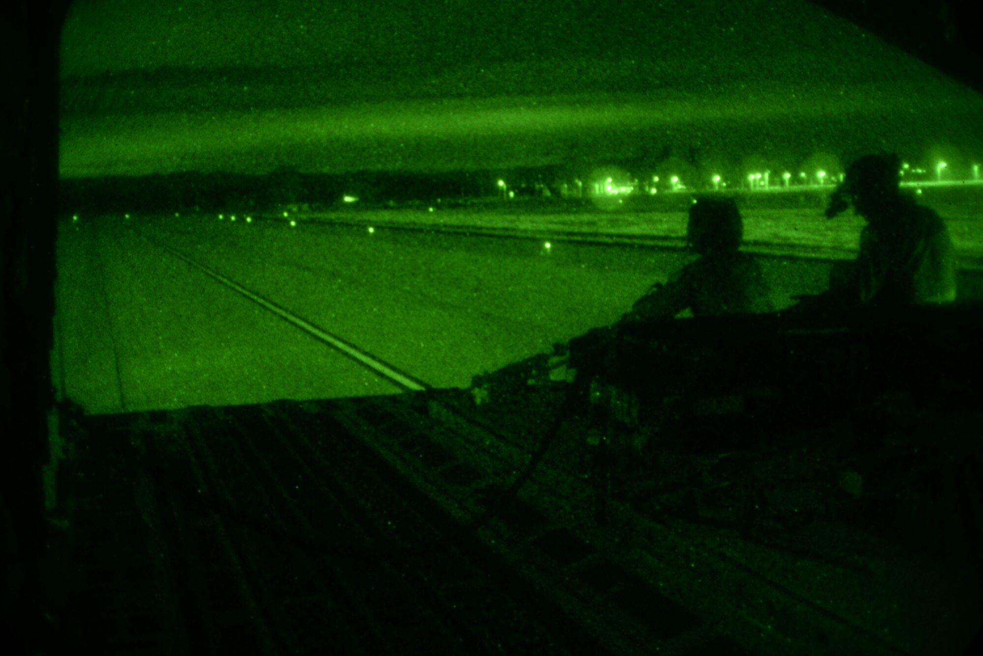 Master Sgt. Shevaun Reighter, 21st Airlift Squadron instructor loadmaster, trains Master Sgt. Ronald Strayhorne, 21st AS loadmaster, March 2 at Travis Air Force Base, California. Reighter and Strayhorne donned night vision goggles and practiced combat offloads to simulate contingency operations. (U.S. Air Force photo by Airman 1st Class Amber Carter) 