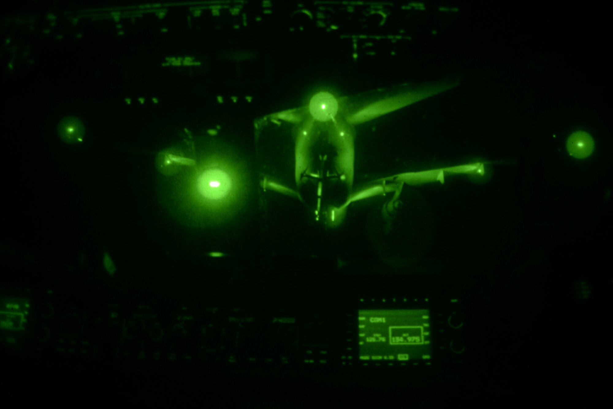 A night vision lens captures a KC-10 Extender as it positions itself above a C-17 Globemaster III March 2 for a late-night aerial refuel. Both of the aircrafts were from Travis Air Force Base, California. The refuel was part of the night training for the C-17 pilots. (U.S. Air Force photo by Airman 1st Class Amber Carter) 