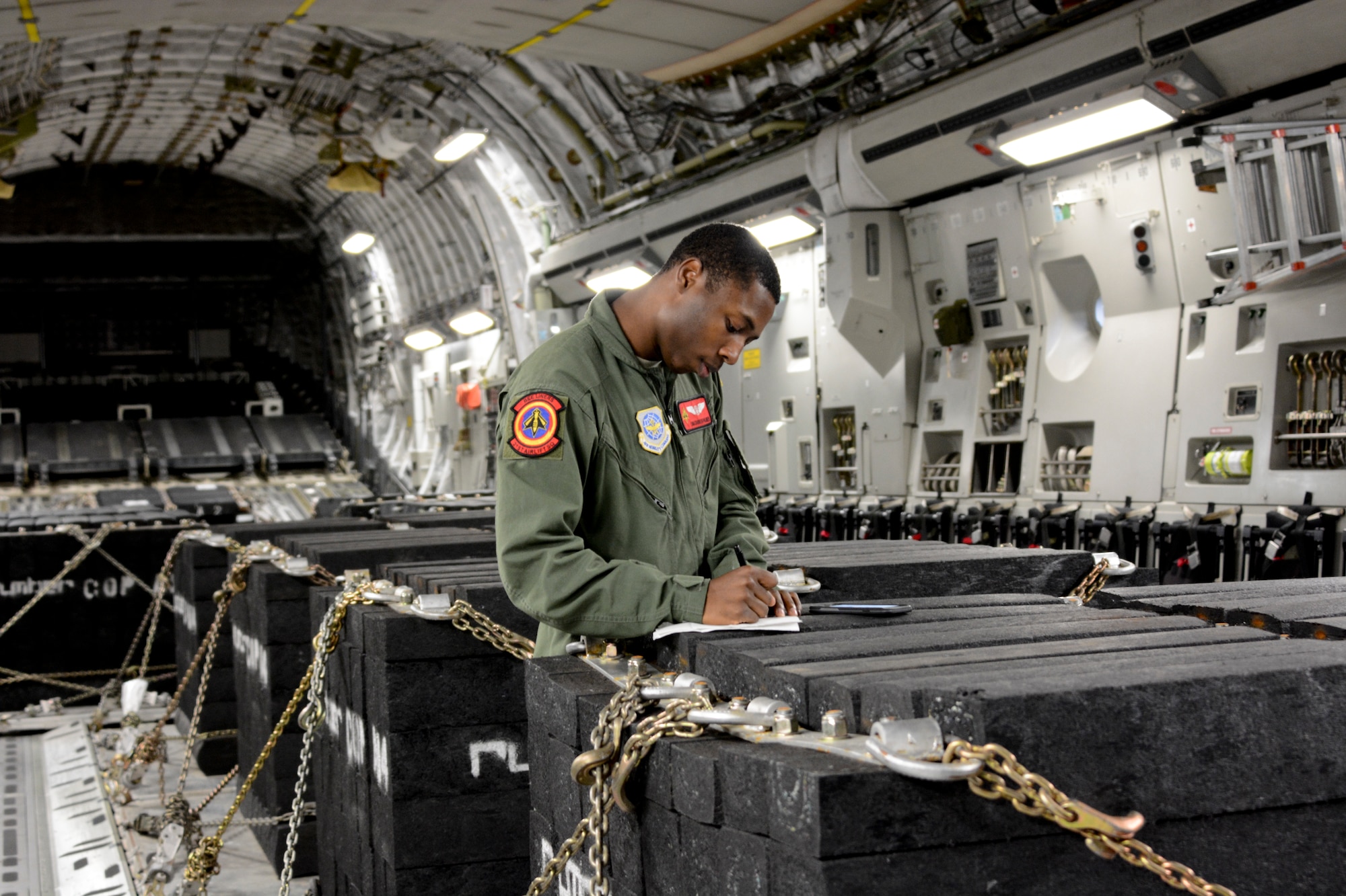 Senior Airman Charles Palmer, 21st Airlift Squadron loadmaster, performs preflight checks at Travis Air Force Base, California. Palmer was part of the six-Airman crew honoring the Tuskegee Airmen. (U.S. Air Force photo by Airman 1st Class Amber Carter) 