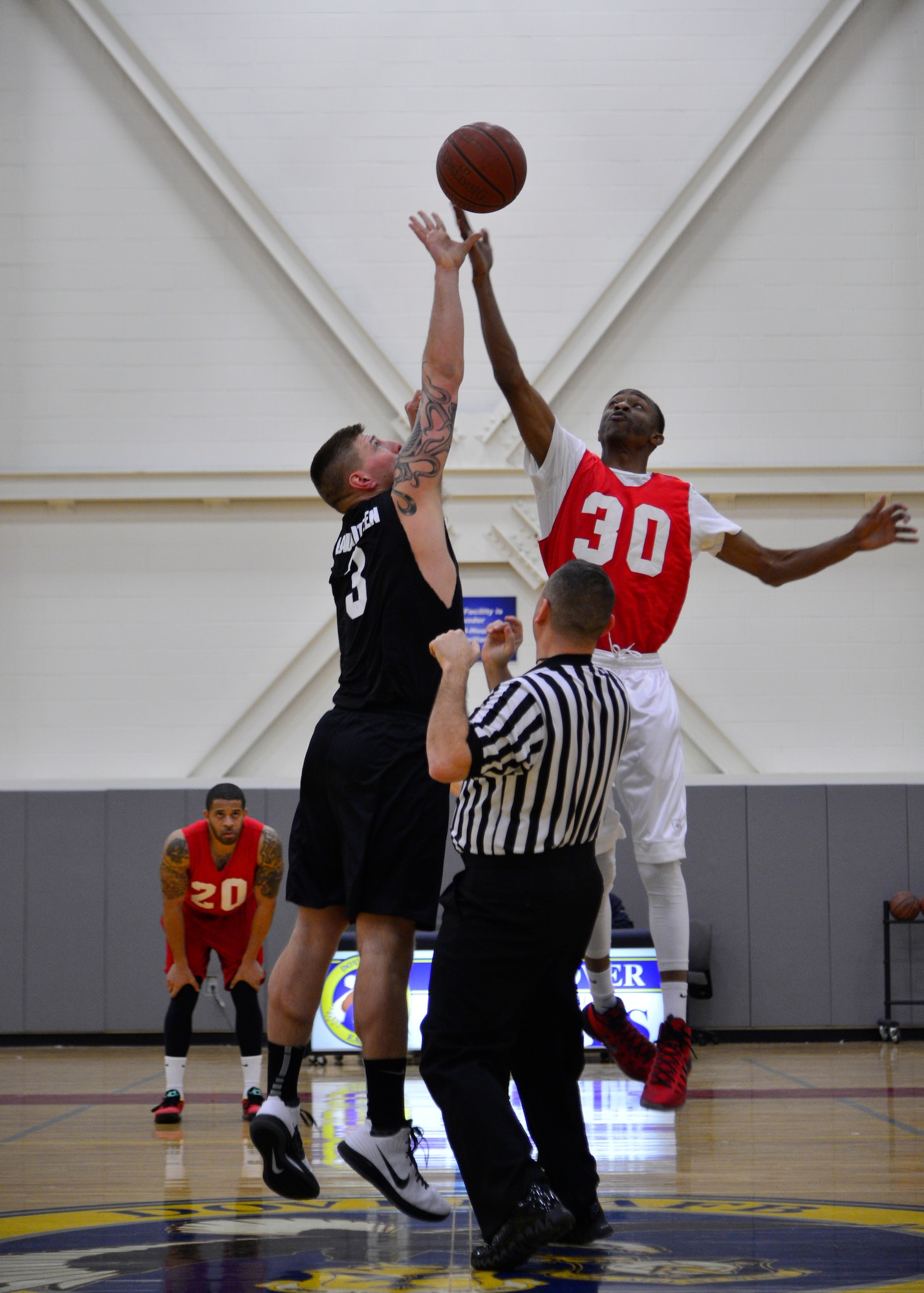 Daniel Lauritzen, 436th Aerial Port Squadron center, left, and Deanthony Rosser, 436th Force Support Squadron/512th Airlift Wing center, tip off the ball at the start of the intramural basketball championship game March 1, 2016, at the Fitness Center on Dover Air Force Base, Del. The 436th APS won the championship game in overtime, 82-73. (U.S. Air Force photo/Senior Airman William Johnson)